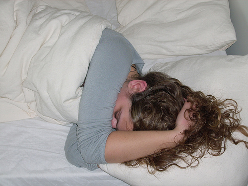 頭を抱えて寝る女性